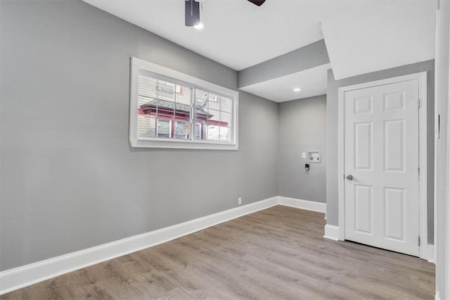 empty room with ceiling fan and light hardwood / wood-style floors