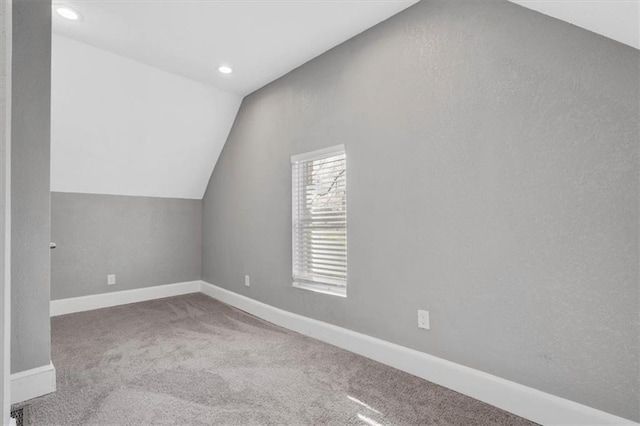 additional living space with carpet floors and vaulted ceiling