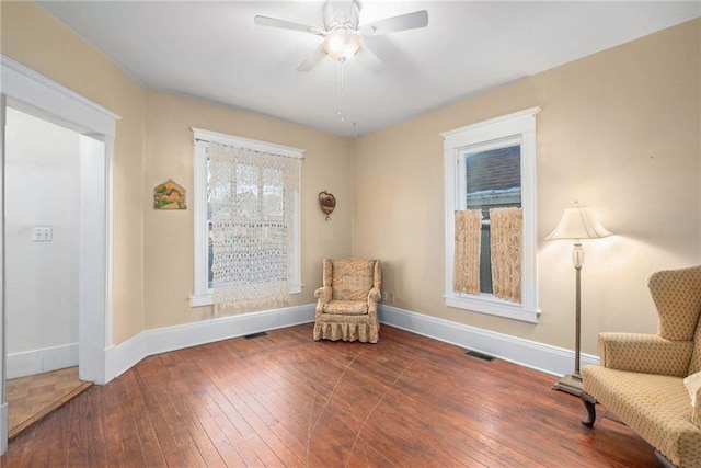 living area with plenty of natural light, dark hardwood / wood-style floors, and ceiling fan