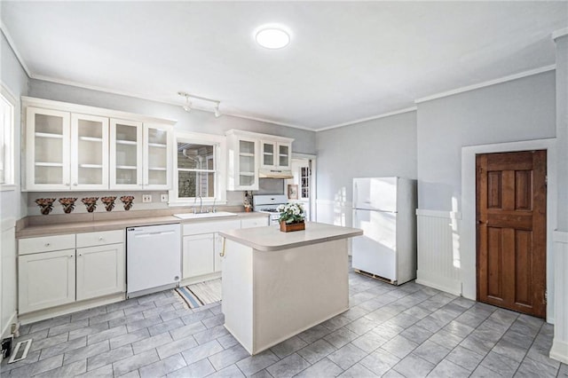 kitchen with white cabinets, white appliances, a center island, and sink