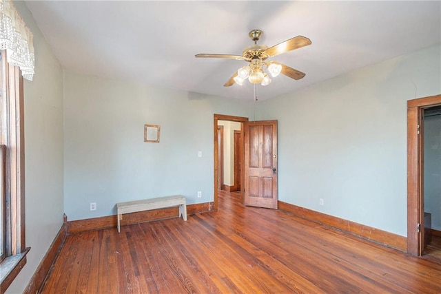 empty room with dark hardwood / wood-style flooring and ceiling fan