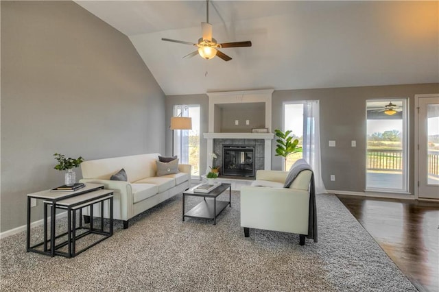 living room featuring hardwood / wood-style flooring, lofted ceiling, and a tiled fireplace