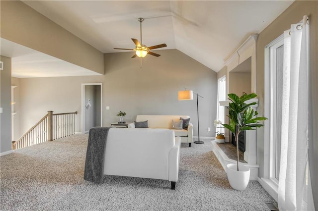 carpeted living room with ceiling fan and vaulted ceiling