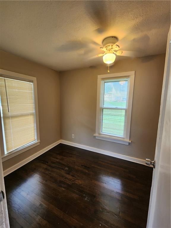 spare room with ceiling fan, dark hardwood / wood-style flooring, and a textured ceiling