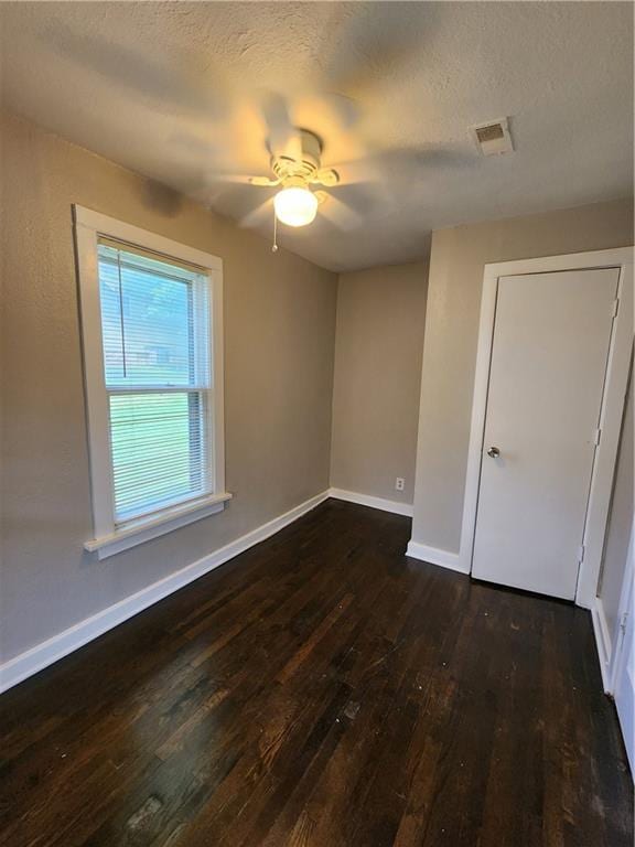 spare room featuring a textured ceiling, ceiling fan, and dark hardwood / wood-style floors