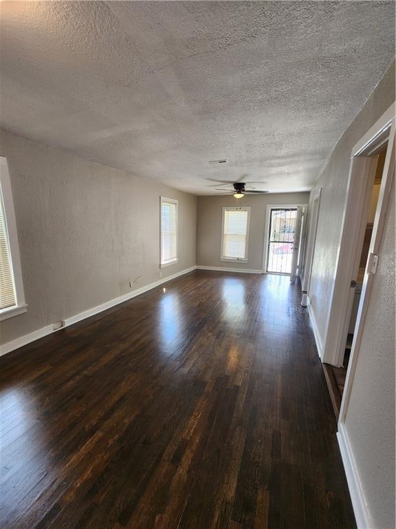 empty room featuring ceiling fan, dark hardwood / wood-style flooring, and a textured ceiling