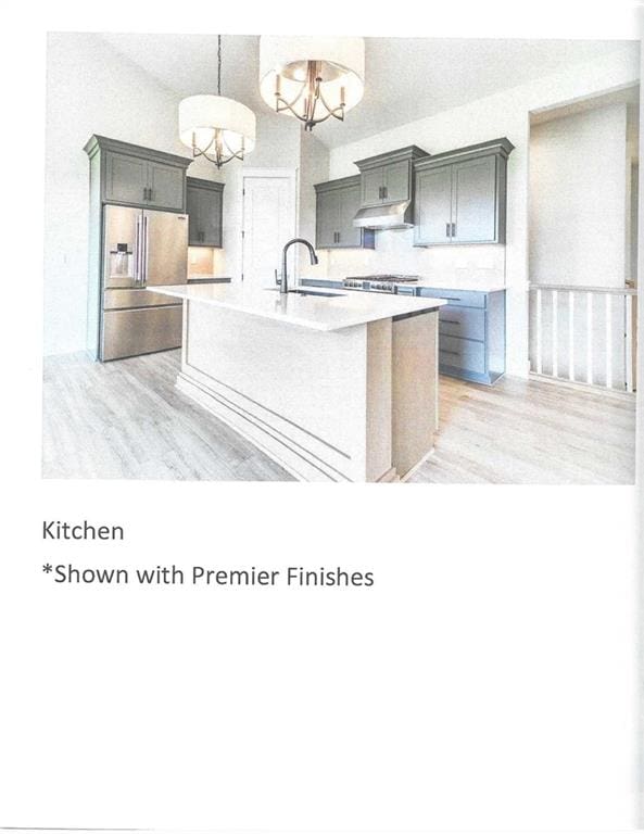 kitchen with a notable chandelier, pendant lighting, light hardwood / wood-style floors, a center island with sink, and appliances with stainless steel finishes