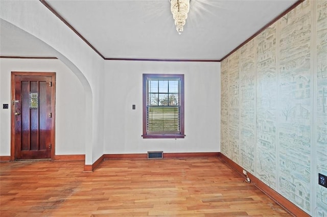 empty room featuring ornamental molding and light hardwood / wood-style flooring