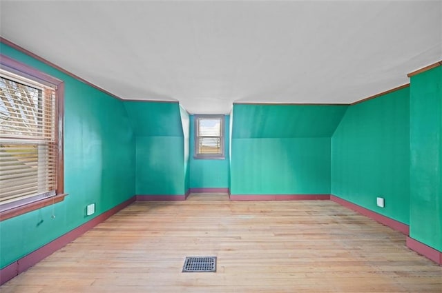 bonus room with lofted ceiling and light wood-type flooring