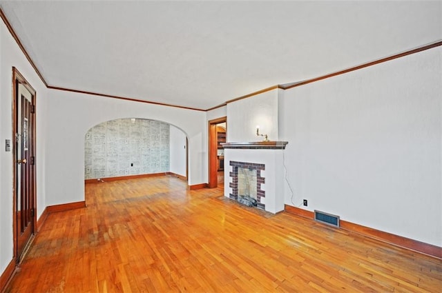 unfurnished living room featuring crown molding and light hardwood / wood-style flooring