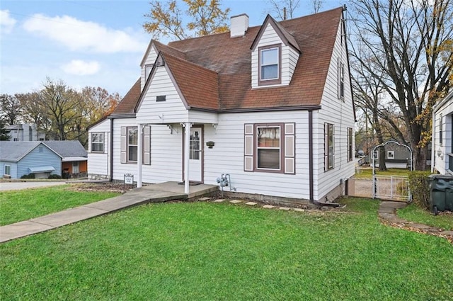 view of front of home featuring roof with shingles, a chimney, and a front yard