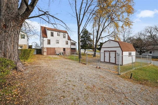 view of yard featuring a gate, fence, and an outdoor structure