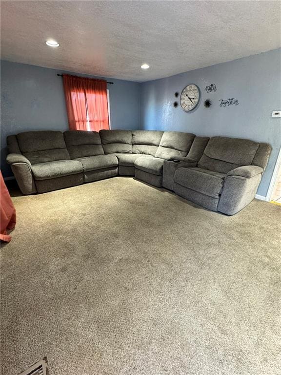 carpeted living room featuring a textured ceiling