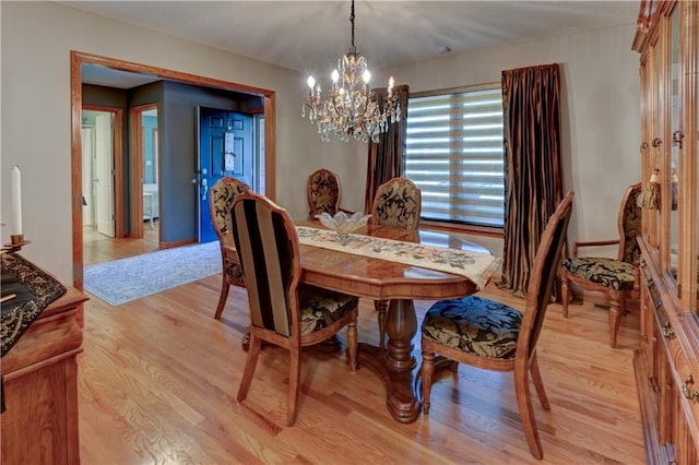 dining room featuring a notable chandelier and light wood-type flooring