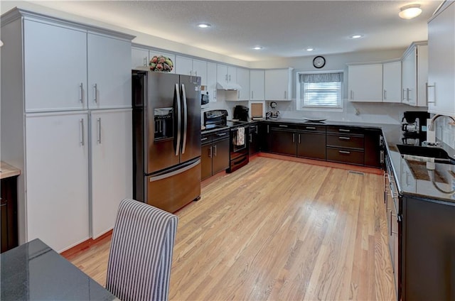 kitchen featuring sink, white cabinetry, stainless steel appliances, and light hardwood / wood-style flooring