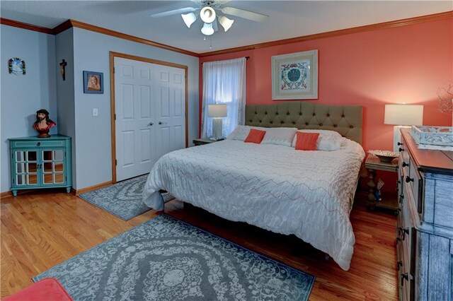 bedroom featuring ceiling fan, a closet, wood-type flooring, and ornamental molding