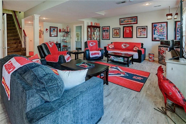 living room featuring light hardwood / wood-style floors and ornate columns