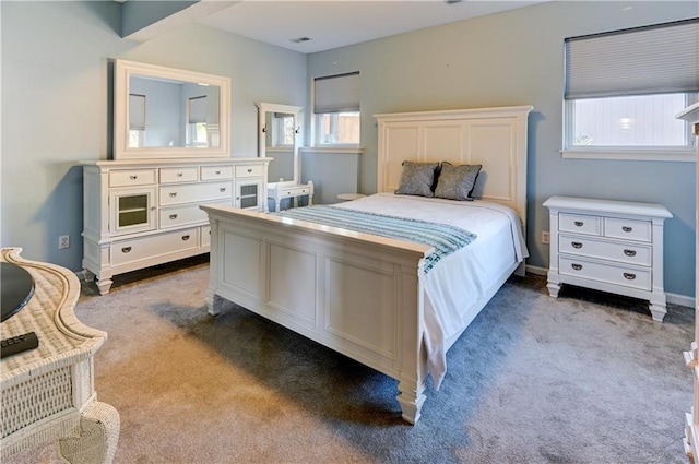 carpeted bedroom featuring multiple windows