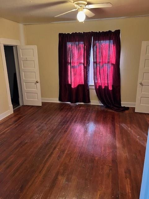 spare room featuring ceiling fan and dark wood-type flooring