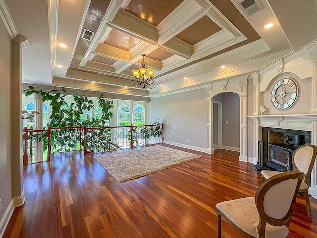 interior space featuring coffered ceiling, crown molding, dark hardwood / wood-style floors, a fireplace, and a chandelier