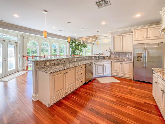 kitchen featuring pendant lighting, plenty of natural light, light hardwood / wood-style floors, and stainless steel appliances