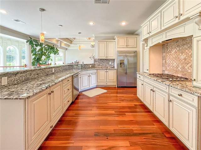 kitchen featuring decorative backsplash, light wood-type flooring, ornamental molding, stainless steel appliances, and hanging light fixtures