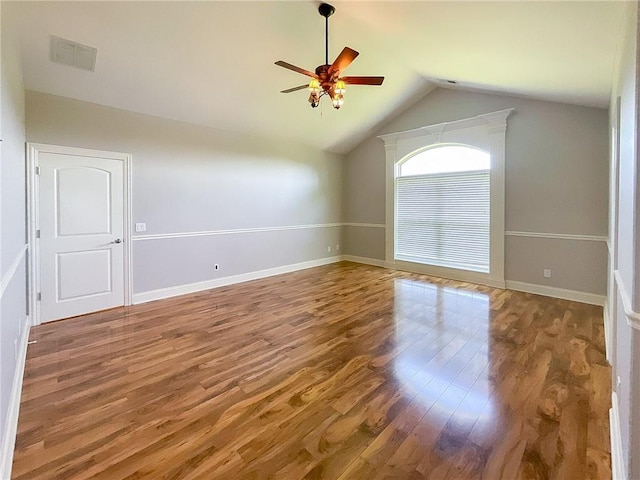 empty room with hardwood / wood-style flooring, vaulted ceiling, and ceiling fan