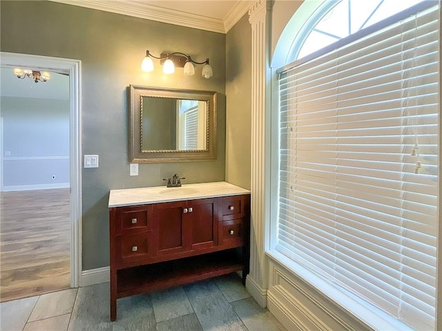 bathroom featuring vanity, wood-type flooring, crown molding, and a chandelier