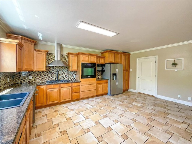 kitchen featuring dark stone counters, black appliances, crown molding, wall chimney exhaust hood, and tasteful backsplash