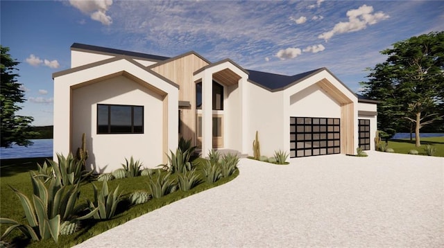 16 Checotah Bluffs Cir, Lake Winnebago, MO 64034 - view of front facade featuring concrete driveway, an attached garage, stucco siding, and a water view