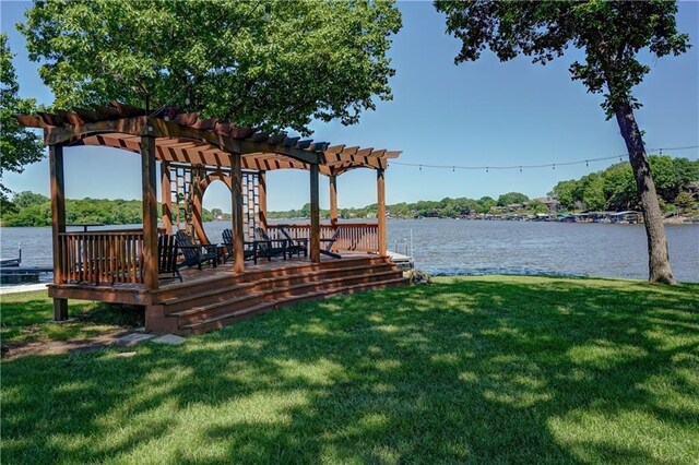 view of dock featuring a deck with water view, a pergola, and a lawn