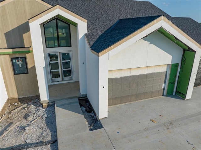 16 Checotah Bluffs Cir, Lake Winnebago, MO 64034 - entrance to property featuring a shingled roof, a garage, and concrete driveway