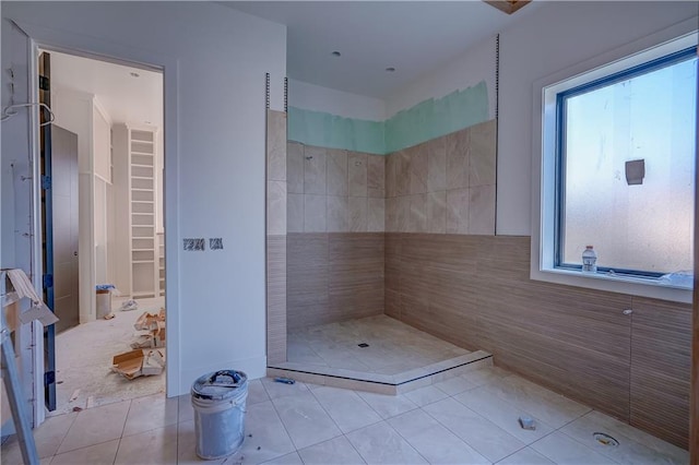 16 Checotah Bluffs Cir, Lake Winnebago, MO 64034 - full bathroom featuring a tile shower, tile patterned flooring, a walk in closet, and tile walls