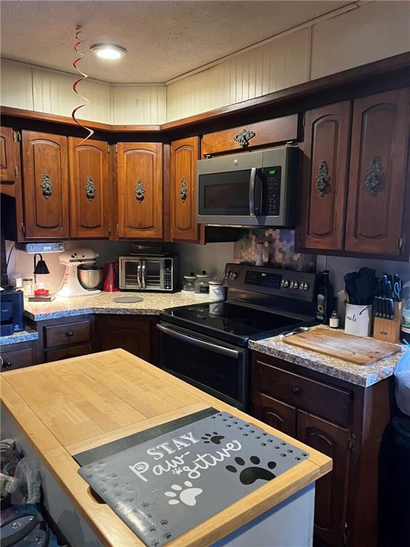 kitchen with a textured ceiling and appliances with stainless steel finishes