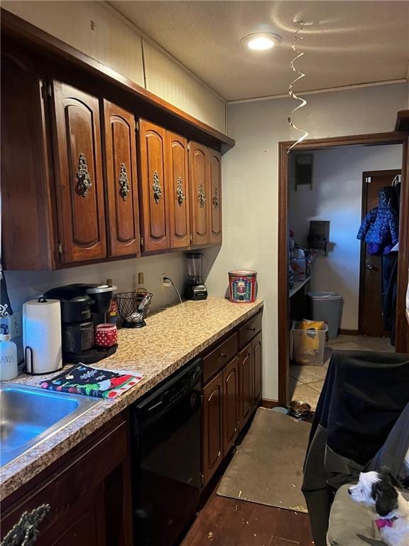 kitchen with dishwasher, dark tile patterned floors, and sink