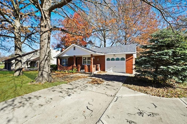 ranch-style house featuring a front yard, a porch, and a garage