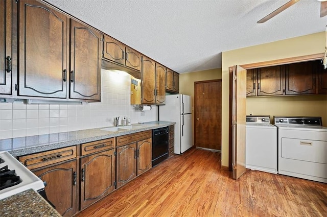 kitchen with ceiling fan, sink, light hardwood / wood-style flooring, independent washer and dryer, and white appliances