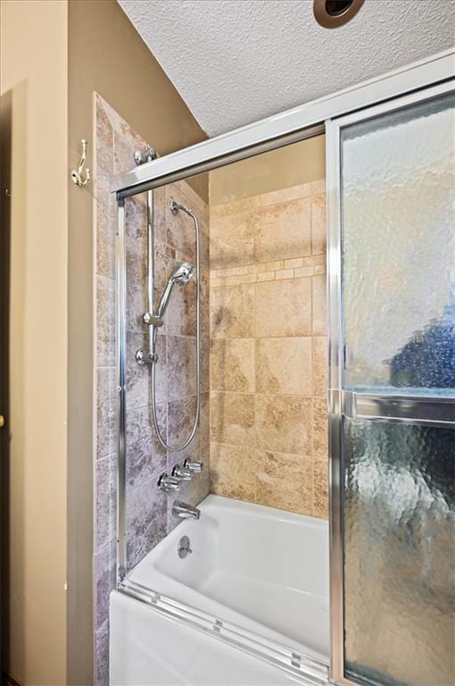 bathroom featuring a textured ceiling and enclosed tub / shower combo