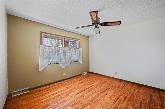 spare room featuring ceiling fan, light hardwood / wood-style floors, and a textured ceiling