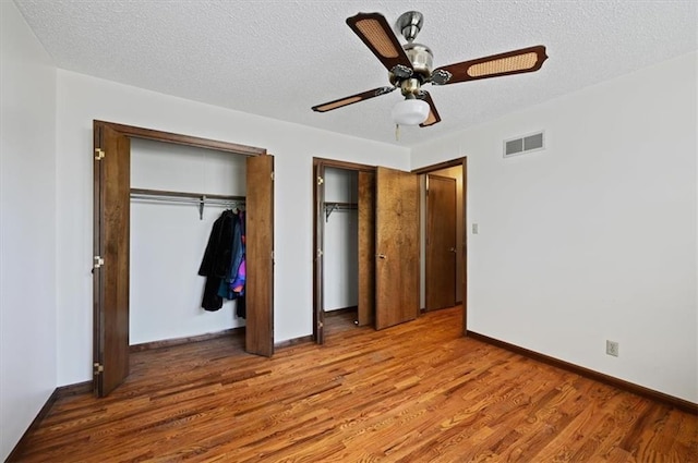 unfurnished bedroom featuring ceiling fan, light hardwood / wood-style floors, and a textured ceiling