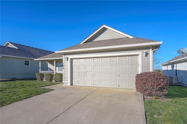 view of front of home with cooling unit, a front lawn, and a garage