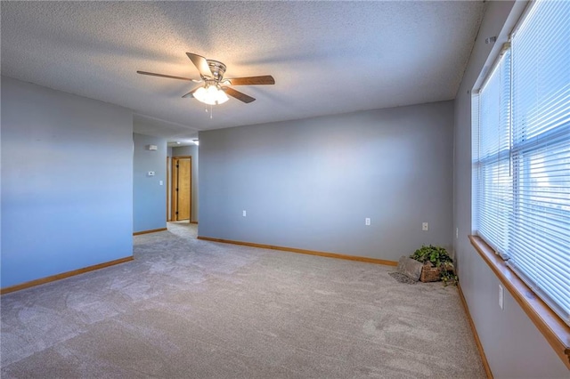 carpeted empty room with a textured ceiling and ceiling fan