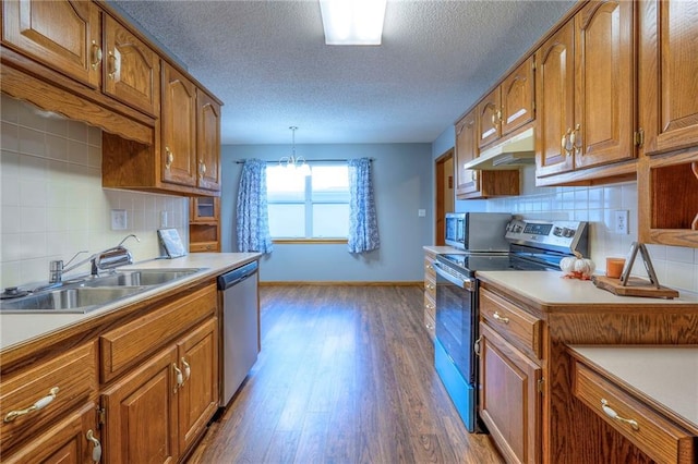 kitchen featuring sink, hanging light fixtures, dark hardwood / wood-style floors, backsplash, and appliances with stainless steel finishes