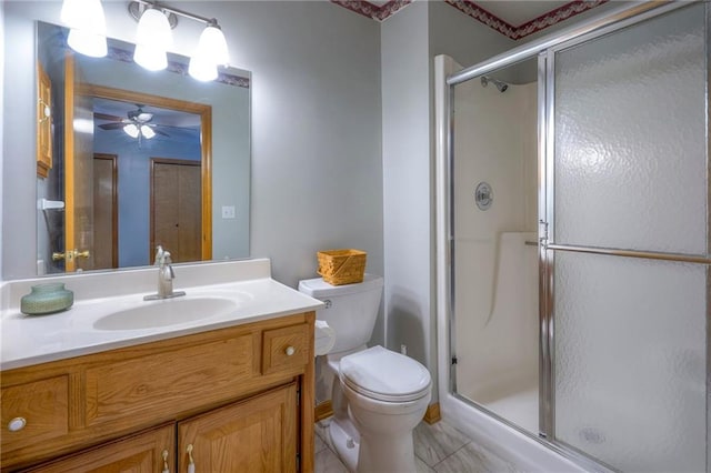 bathroom with ceiling fan, tile patterned floors, toilet, vanity, and a shower with shower door