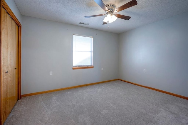 unfurnished bedroom featuring ceiling fan, a closet, carpet, and a textured ceiling