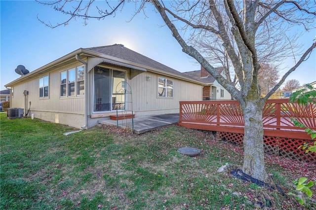 rear view of property with a lawn, central AC unit, a patio, and a wooden deck