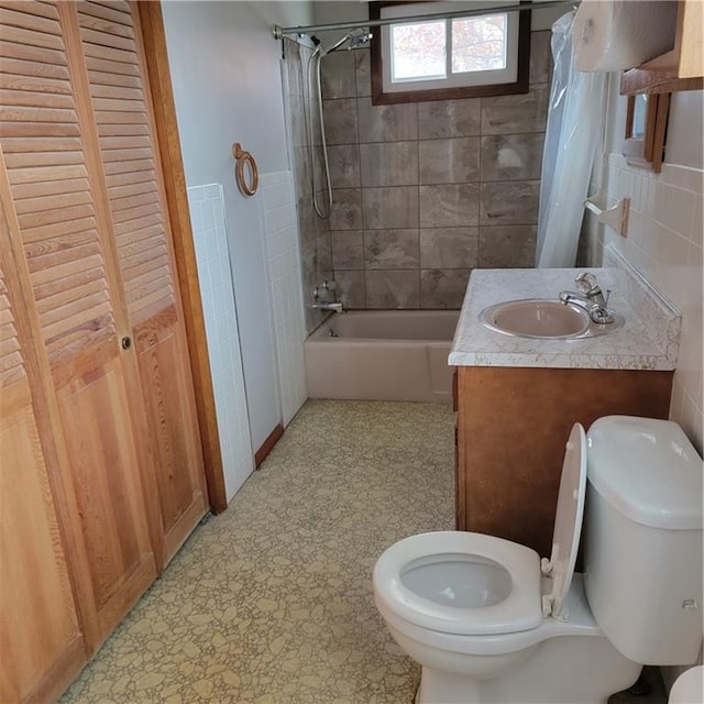 full bathroom with vanity, toilet, shower / bath combo, and tile walls