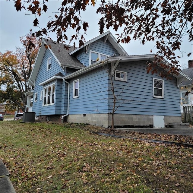 view of home's exterior with central air condition unit and a yard