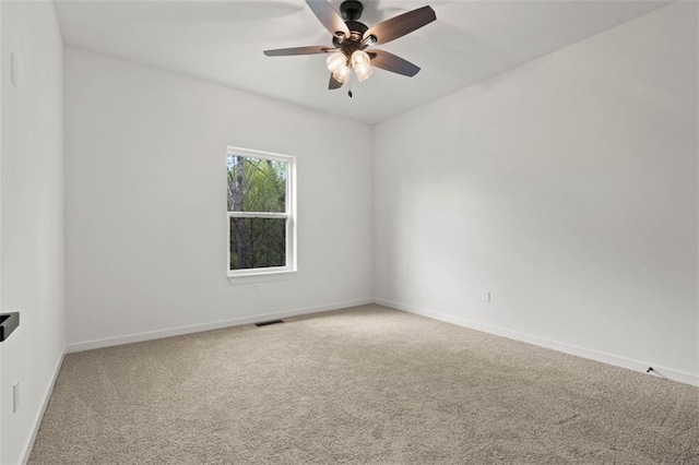 carpeted spare room with ceiling fan, baseboards, and visible vents