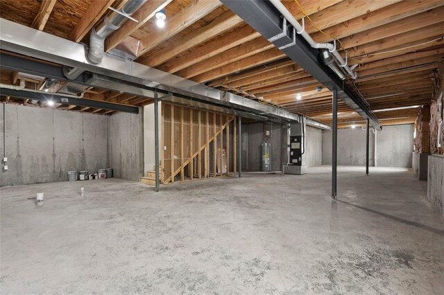 unfinished basement featuring heating unit and water heater